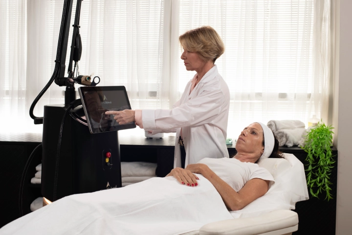 Protocolo de Resurfacing: Winter Reset 2 Profesional médica configurando equipo Alma Hybrid mientras una paciente permanece recostada en camilla en clínica estética.